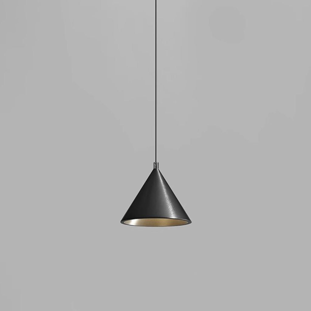 A modern cone-shaped pendant light with a matte black exterior and a brushed gold interior, suspended by a thin black cord against a solid gray background.