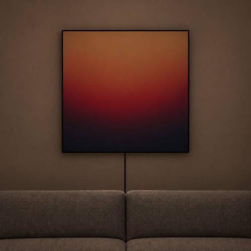 A square abstract wall art print with a gradient from warm orange and red to deep red and black, hanging on a brown wall above a gray sofa.